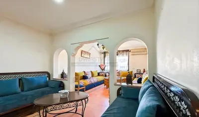 a living room with a blue couch and a table at Appartement charmant à Guéliz in Marrakech