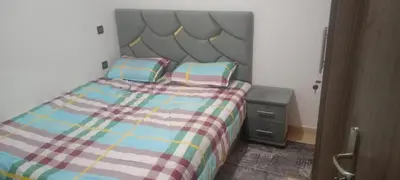 a bed with two pillows and a night stand in a bedroom at المغرب in Marrakech