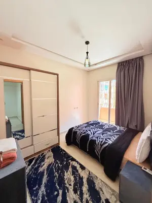 a bedroom with a bed and a mirror at Appart N35 COSY CONFORT FAMILY in Marrakech