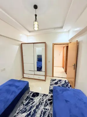 a bedroom with two beds and a mirror at Appart N35 COSY CONFORT FAMILY in Marrakech