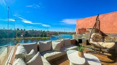 a patio with a couch and chairs and a large window at Appartement PRESTIGIA MARRAKECH VILLAGE in Marrakech