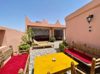 a patio with a yellow table and benches at Terrace Room with Atlas View in Marrakech