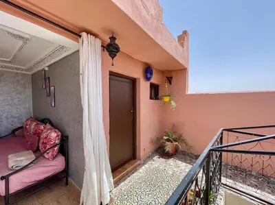 a room with a balcony with a couch and a window at Terrace Room with Atlas View in Marrakech