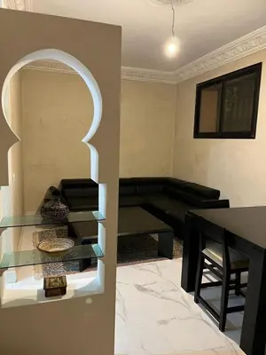 a living room with a glass table and a couch at Joli appartement proche aéroport in Marrakech