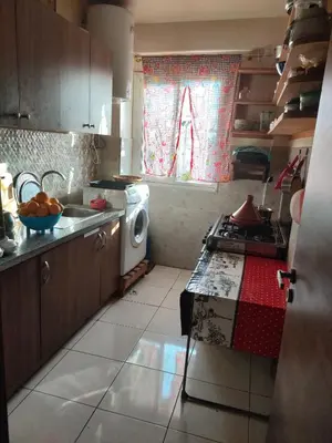 a kitchen with a sink and a washing machine at Mhamid10, Albahja Route Agafay in Soltane