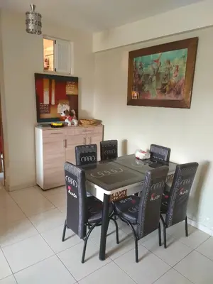 a dining room table with four chairs and a kitchen at Mhamid10, Albahja Route Agafay in Soltane