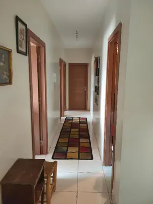a hallway with a door and a table and some rugs at Mhamid10, Albahja Route Agafay in Soltane