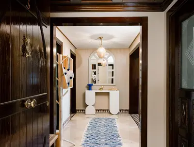 a hallway with a door and a table in a room at Zellige Suite - Gouvernante et piscine ! in Marrakech