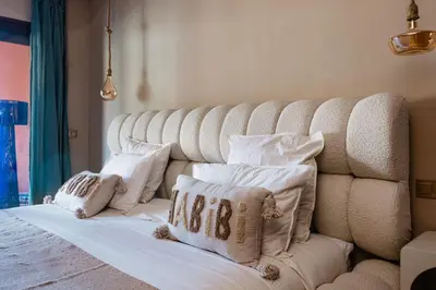 a bedroom with a white bed with pillows on it at Zellige Suite - Gouvernante et piscine ! in Marrakech