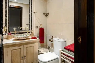 a bathroom with a toilet and a sink and a mirror at Zellige Suite - Gouvernante et piscine ! in Marrakech