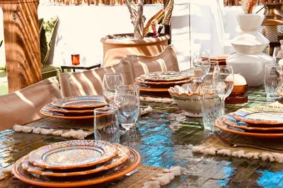 a table with plates and glasses on top of it at Riad de charme Aïtana au cœur de la Médina in Marrakech