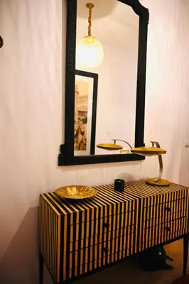 a mirror on top of a table with a sink at Riad de charme Aïtana au cœur de la Médina in Marrakech