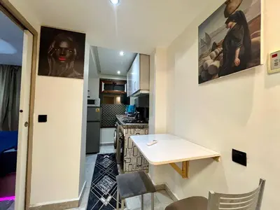 a small kitchen with a small table and a counter at appartement guliz in Marrakech