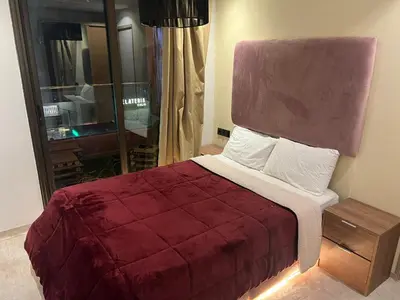 a bedroom with a bed with a red comforter at appartement guliz in Marrakech