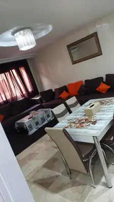 a living room with a table and a couch at Le Central Hivernage 8-37-44 face gare CTM et a 10mn de l'aéroport in Marrakech
