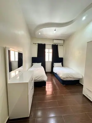 a room with two beds and a desk in it at Élégant Appartement 2 Chambres avec Piscine et Climatisation à Guéliz in Marrakech