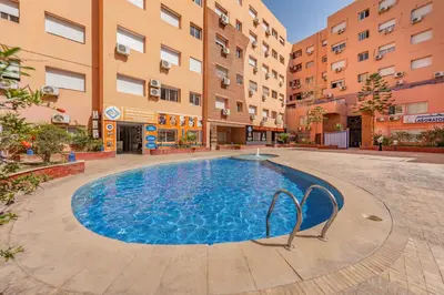 a swimming pool in the middle of a building at Élégant Appartement 2 Chambres avec Piscine et Climatisation à Guéliz in Marrakech