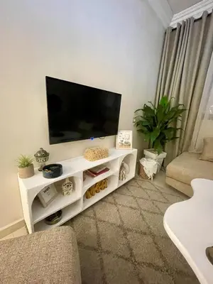 a living room with a flat screen tv on a white entertainment center at Dar Mimouna - Authenticité & Confort Moderne in Marrakech