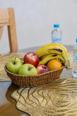 a basket of apples oranges and bananas on a table at 1BR Appart 2 min de M Avenue , Pool , Balcony & Parking & 24h j7 security in Marrakech