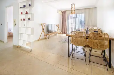 a dining room with a table and rattan chairs at La Menara - 2 Chambres - Centre - Wifi in Marrakech
