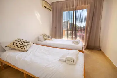 two twin beds in a room with a window at La Menara - 2 Chambres - Centre - Wifi in Marrakech