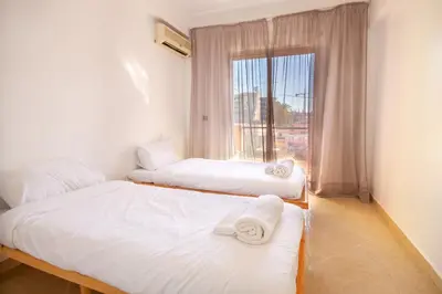 two beds in a room with a window at La Menara - 2 Chambres - Centre - Wifi in Marrakech