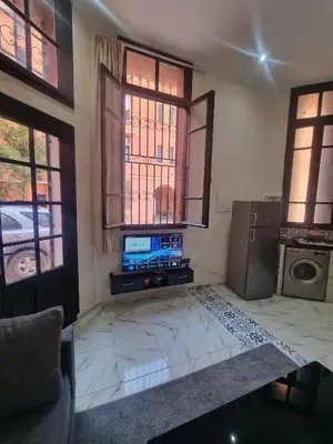 a living room with a tv and a couch and windows at Guéliz Spirit in Marrakech