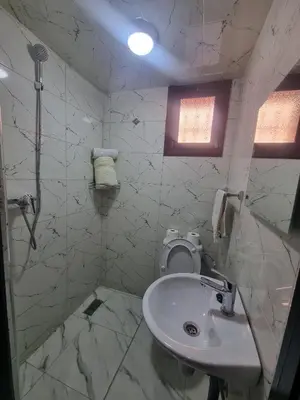 a white bathroom with a toilet and a sink at Guéliz Spirit in Marrakech