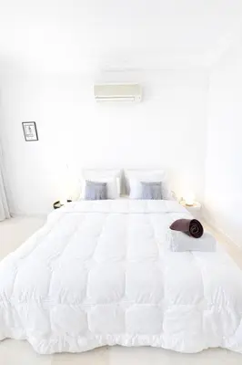 a white bedroom with a large white bed at Luxe Studio 2min Carre Eden in Marrakech