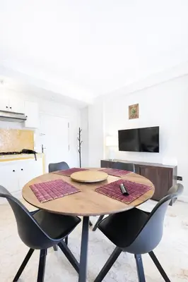 a dining room with a wooden table and chairs at Luxe Studio 2min Carre Eden in Marrakech