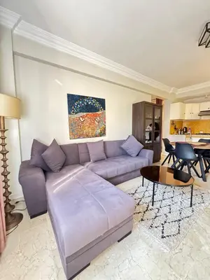 a living room with a couch and a table at Luxe Studio 2min Carre Eden in Marrakech