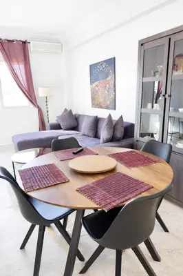 a dining room table with chairs and a couch at Luxe Studio 2min Carre Eden in Marrakech