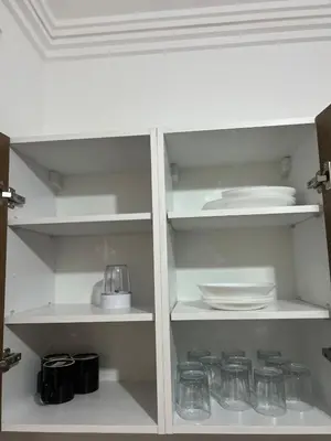a white cabinet with plates and dishes on it at Cozy Apartment With Pool 5 min from Guéliz in Marrakech