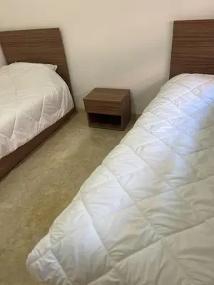 a bedroom with two beds and a night stand at Cozy Apartment With Pool 5 min from Guéliz in Marrakech