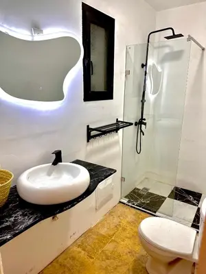 a white bathroom with a sink and a shower at Les Paniers de MARRAKECH 1 in Marrakech