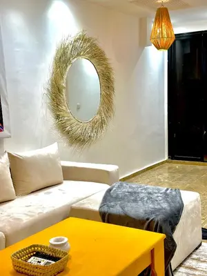 a living room with a couch and a mirror at Les Paniers de MARRAKECH 1 in Marrakech
