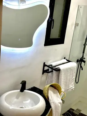 a bathroom with a sink and a mirror and towels at Les Paniers de MARRAKECH 1 in Marrakech