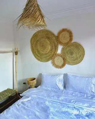 a bedroom with a bed with baskets on the wall at Les Paniers de MARRAKECH 1 in Marrakech