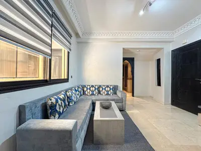 a living room with a couch and a coffee table at Studio moderne avec terrasse, piscine et parking à Guéliz, Marrakech in Marrakech