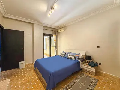 a bedroom with a blue bed and a tv at Studio moderne avec terrasse, piscine et parking à Guéliz, Marrakech in Marrakech