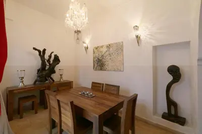 a dining room with a wooden table and a chandelier at Riad XCIX, basin, 3 bedrooms in Medina excluded in Marrakech