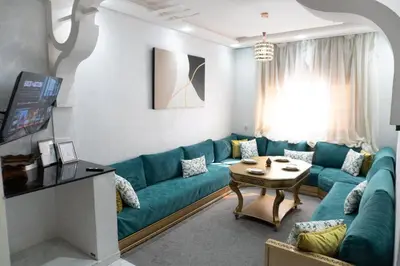 a living room with a blue couch and a table at Appartement de luxe, à 2min de Guéliz in Marrakech