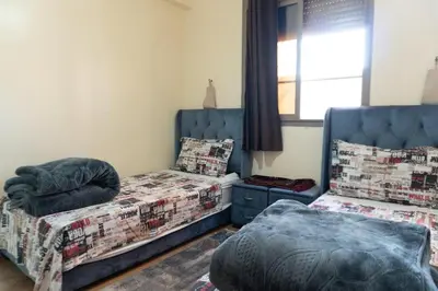 a bedroom with two beds and a window at Appartement de luxe, à 2min de Guéliz in Marrakech