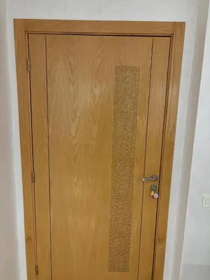 a wooden door in a room next to a wall at Gemütliche Wohnung in Marakesch in Marrakech