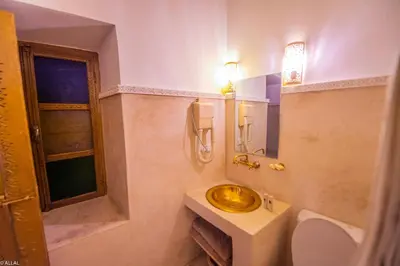 a bathroom with a sink and a toilet and a mirror at Riad Amskal in Marrakech