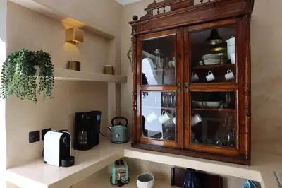 a kitchen with a wooden cabinet with dishes in it at DeaRiad, Medina, Basin, 2 Bedrooms in Marrakech