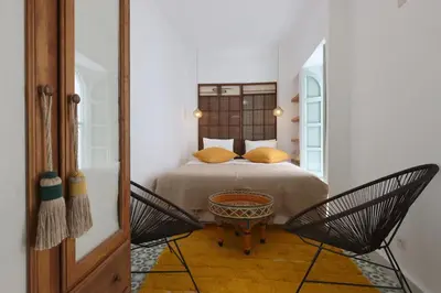 a bedroom with a bed with two chairs and a table at DeaRiad, Medina, Basin, 2 Bedrooms in Marrakech