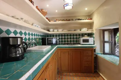 a kitchen with green and white tiled counter top at Dar Jena, Rare Riad in Medina on Mamounia in Marrakech