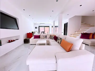 a living room with a white couch and a tv at 3 bedroom villa with private pool near centre in Marrakech