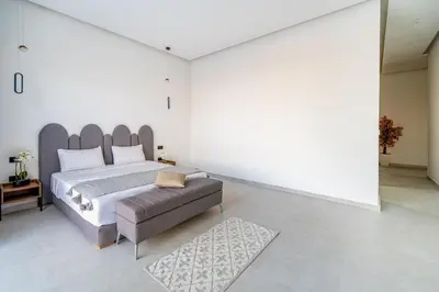 a bedroom with a large bed and a couch at Villa Alia - Piscine Chauffée - 4 BR BA - Wifi - Parking in Marrakech